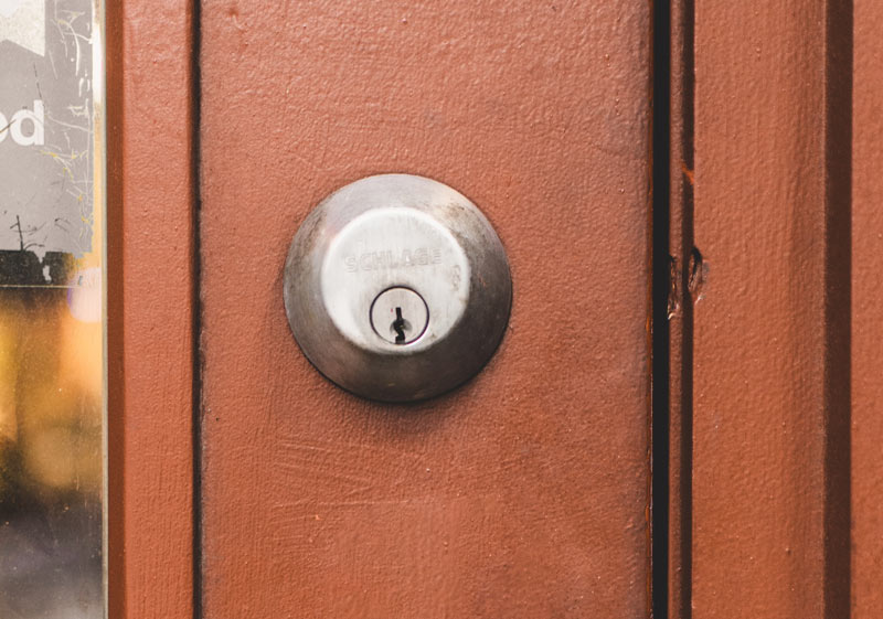 A Schlage deadbolt on a brownish door