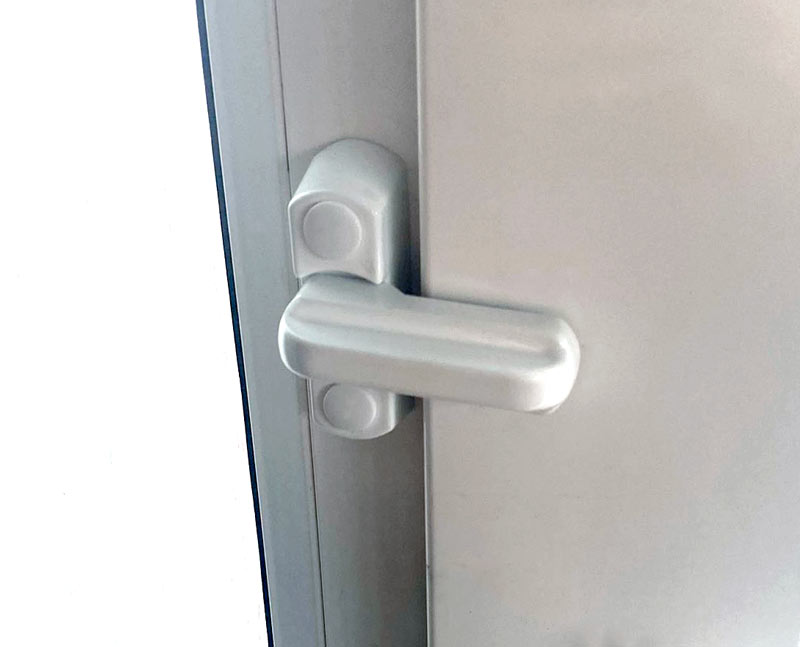 A white sash jammer installed on a door jamb