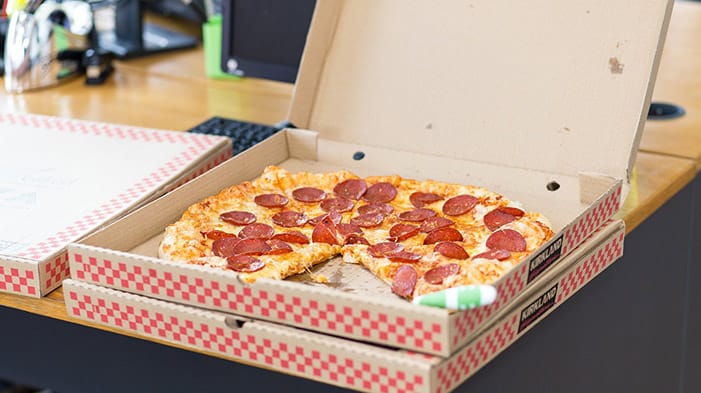 Pizza in an open takeaway cardboard box