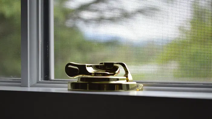A closeup of a window lock of golden color