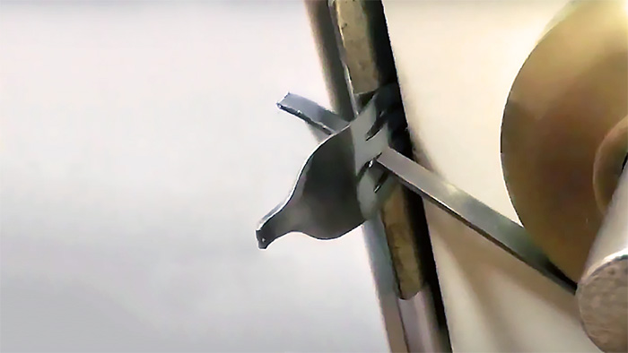 A door locked by a modified fork with its head inserted into the hole of the strike plate   