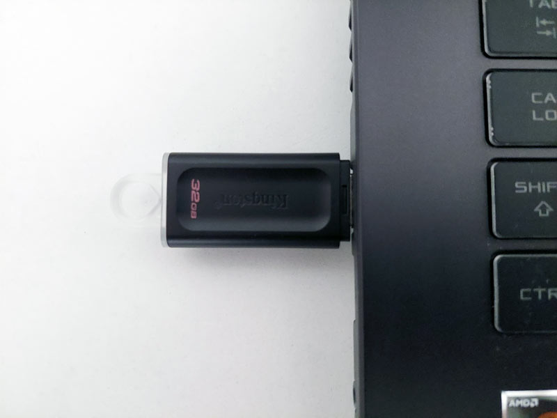A black USB stick plugged into a laptop