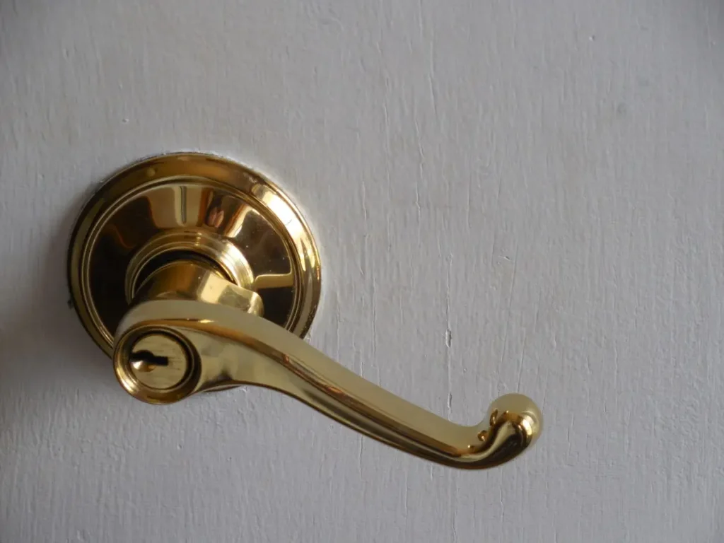 Gold keyed entry lever on a white door