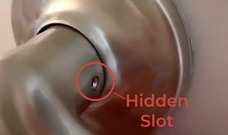 Closeup of a door handle with a tiny hole